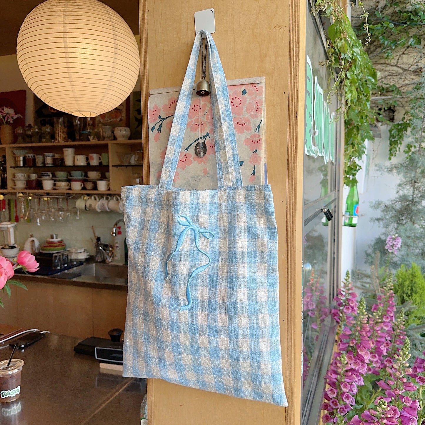 Schultertasche mit bestickter Schleife und Karomuster